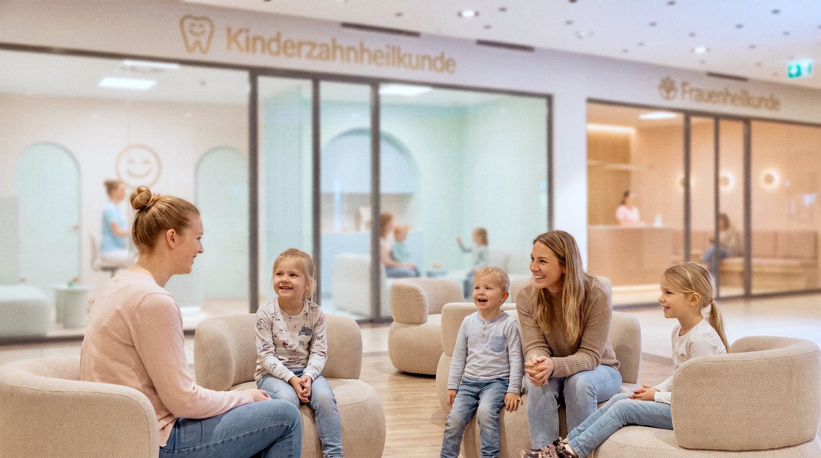 Wartebereich in der überdachten Mall des Porcia MedCenter in Spittal an der Drau, zwei Erwachsene und drei Kinder sitzen in Sesseln